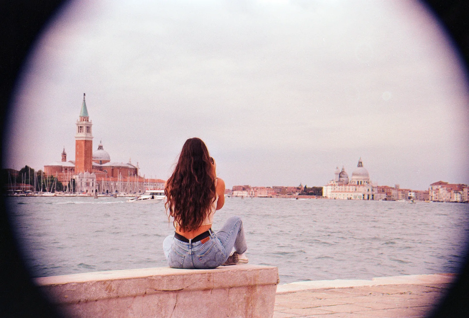 Carmen seated with her back to the camera, looking across the Venetian lagoon.