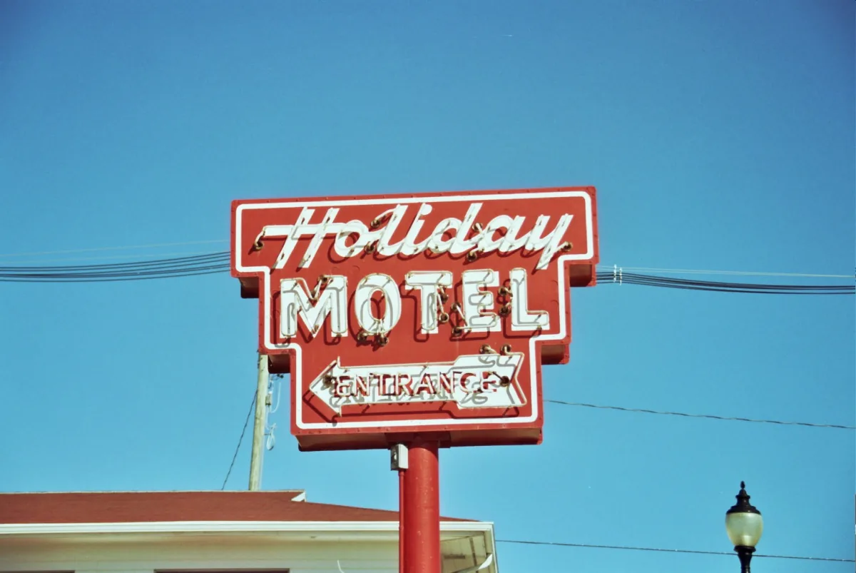 Holiday Motel sign against a clear blue sky.